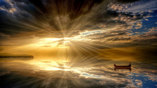 boat in the middle of the sea during crepuscular rays thumbnail