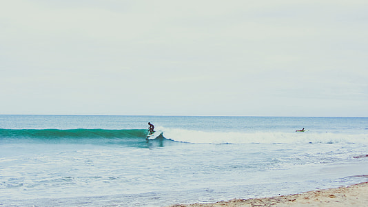 man surfing on green wave during daytime thumbnail