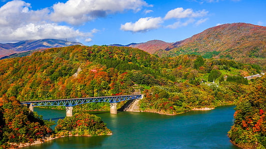 blue and gray concrete bridge in between of mountain during daytime thumbnail