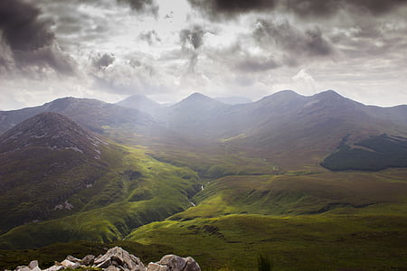 green mountings under cloudy skyt thumbnail