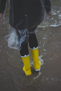 Person Wearing Clear Plastic Raincoat and Pair of Yellow Rainboots thumbnail