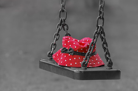 red and white polka dot bucket hat placed on metal swing thumbnail