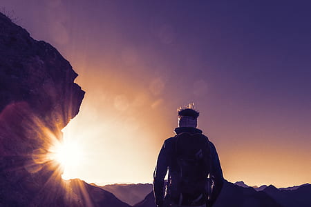 person with backpack standing near rock thumbnail