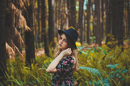woman with black fedora hat near green leaf plants at daytime thumbnail