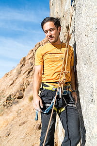 man leaning on grey wall after rapelling thumbnail