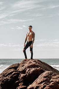 man standing on rock during daytime thumbnail