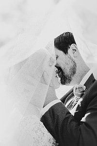 grayscale photograph of bride and groom doing a kiss thumbnail