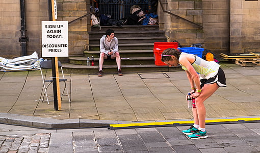 woman holding knees with both hands while on a pathway thumbnail