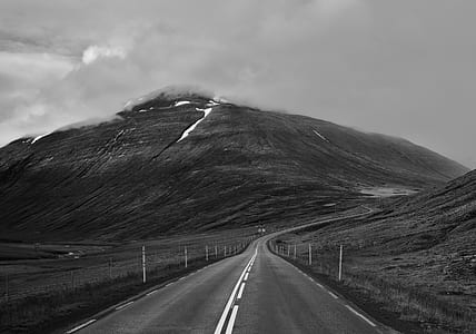 grayscale photo off concrete road leading to mountain thumbnail