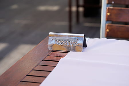 selective focus photo of gray stainless steel reserve embossed ornament on brown wooden table thumbnail