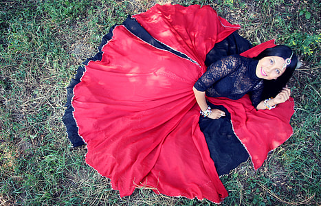 woman in red and black dress lying on grass field thumbnail