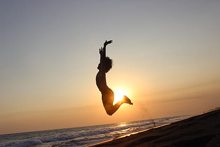 silhouette of child jumping on seashore thumbnail