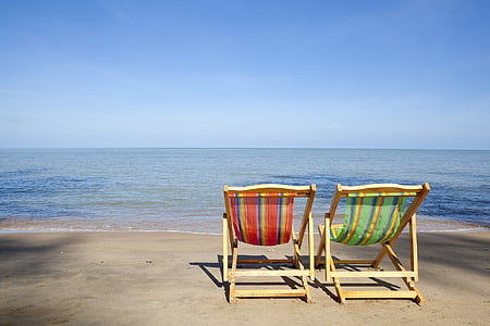 two brown wooden beach chairs on seashore thumbnail