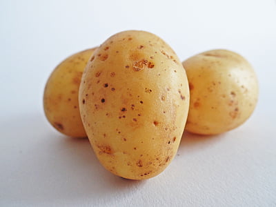 three yellow potatoes on white surface thumbnail