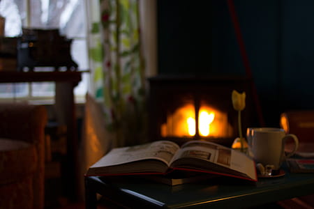white ceramic mug beside book on brown wooden table thumbnail