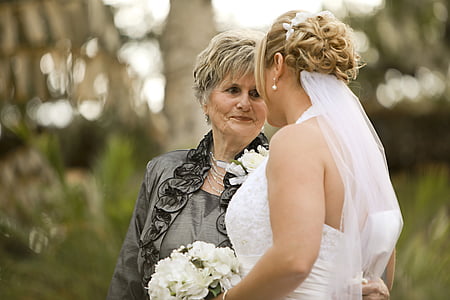 woman wearing wedding dress beside woman wearing gray blazer thumbnail