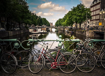 assorted bicycle on bridge near buildings during daytime thumbnail
