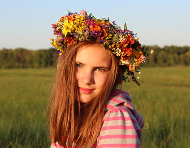 woman in pink and gray striped top wearing yellow, orange, and purple flower crown thumbnail