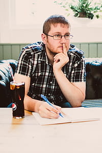 Man Wearing Black Plaid Shirt Sitting thumbnail