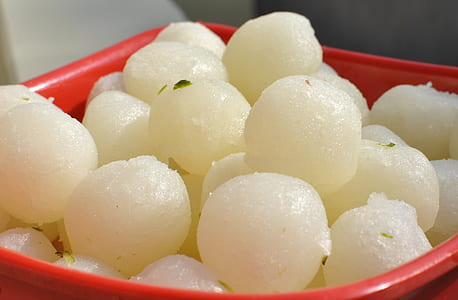 bow of rasgula sweets in red plastic bucket thumbnail