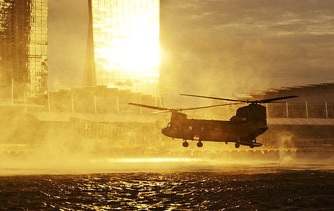 gray carrier helicopter over the sea near city thumbnail