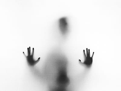 silhouette of person putting his palms on glass wall thumbnail