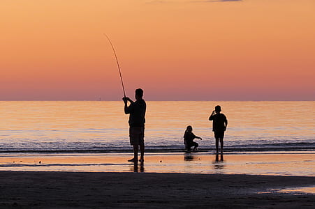 silhouette of three person on seashore thumbnail