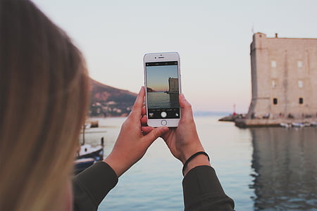 woman showing photo of building near body of water thumbnail