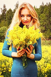 smiling woman holding yellow rapeseed flowers bouquet at daytime thumbnail