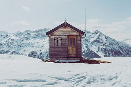 brown wooden cabin on snow capped mountain thumbnail