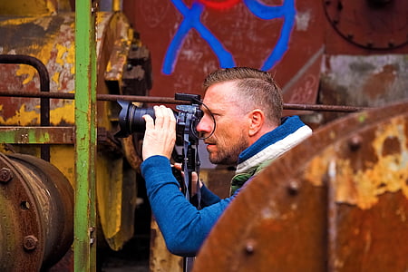 man using black DSLR camera during daytime thumbnail