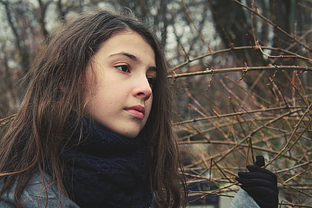 portrait photography of woman near withered trees thumbnail