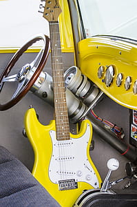 yellow electric guitar in yellow and gray interior car thumbnail