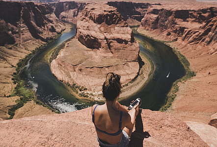 woman sitting on cliff on Horseshoe Bend in Utah thumbnail