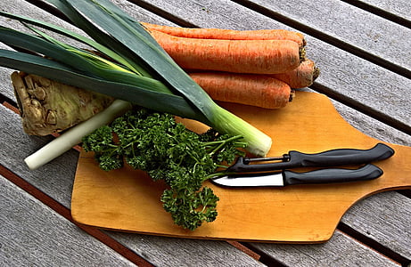 carrots and spring onions with knife on brown chopping board thumbnail