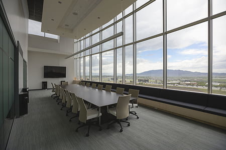 empty rectangular white wooden table with chairs near glass windows thumbnail