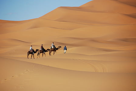 three men riding horse on desert land thumbnail