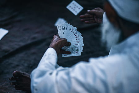 man holding playing cards thumbnail