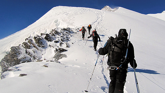 group of people climbing on mountain coated by snow thumbnail