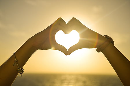 silhouette heart human hand sign with ray of sun thumbnail