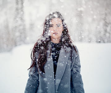 woman in gray coat standing on snowfield thumbnail