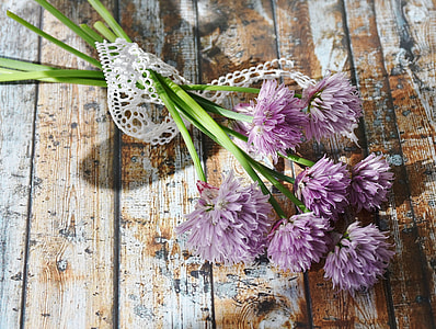pink chive flowers on brown and white wooden surface thumbnail