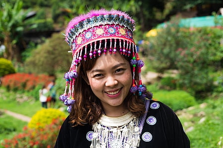 smiling woman wearing black cardigan and multicolored headdress during daytime thumbnail