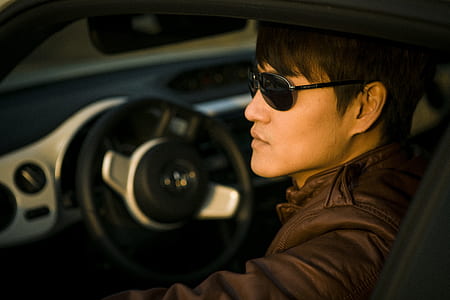 man wearing brown leather jacket inside car thumbnail