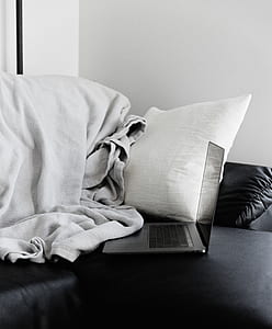 gray laptop computer on gray bed thumbnail