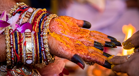 person wearing gold-colored and multicolored bangles thumbnail