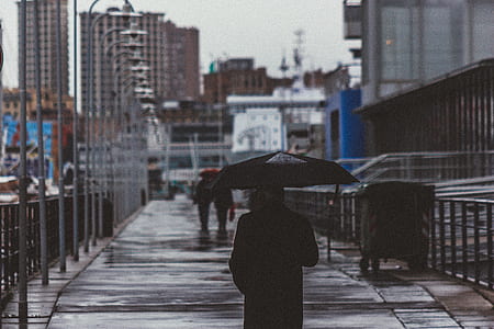 woman wearing black jacket holding a umbrella thumbnail