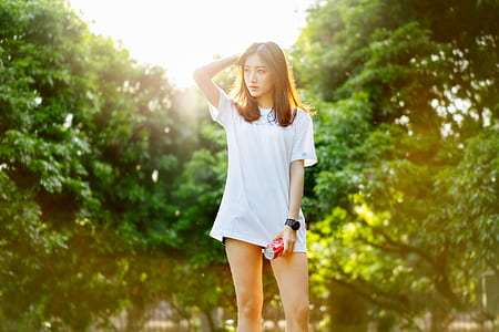 woman wearing white crew-neck shirt standing with right hand on head thumbnail