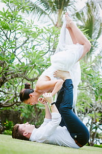 man lifting woman with both hand and feet during daytime thumbnail