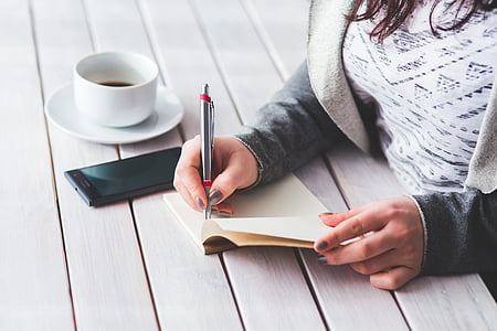 person holding silver click pen thumbnail